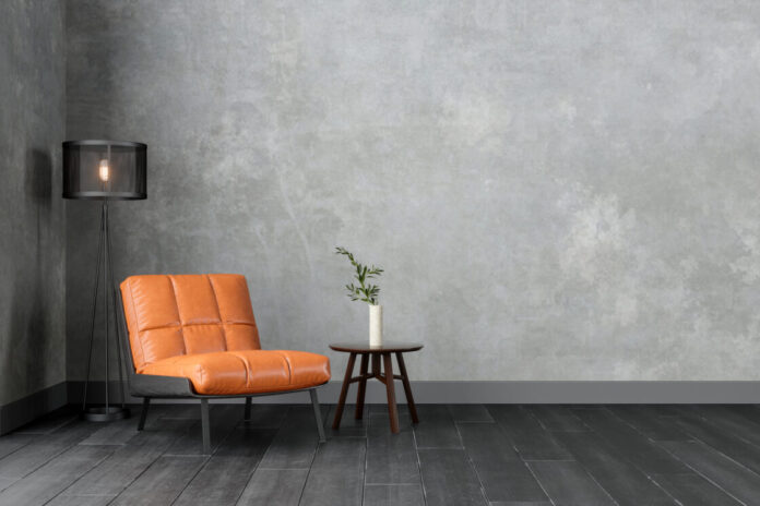 Modern Interior With Orange Colored Leather Armchair, Sconce, Coffee Table And Gray Wall.