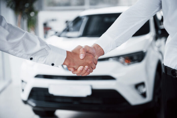 close-up-gerente-de-vendas-em-terno-preto-vendendo-o-carro-para-o-cliente-Easy-Resize.com